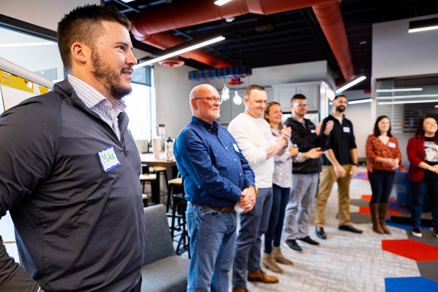 Team members standing up at a meeting.